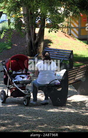 The Fat Woman Is Sitting On The Bench Next Lean Man Stock Photo