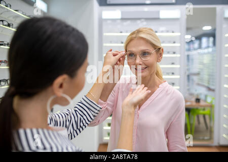 Gorgeous woman trying to choose ideal shape of glasses frame Stock Photo