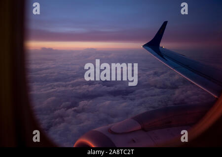 View from the airplane window on pink colorful sunrise Stock Photo