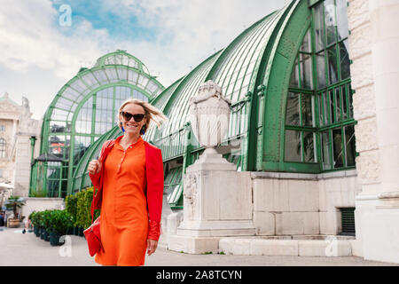 A young woman is walking near Palmenhaus cafe situated next to the hofburg palace in Vienna, Austria Stock Photo