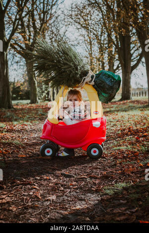 Child driving toy car with christmas tree on top Stock Photo