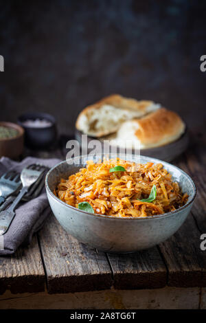 Stewed or braised cabbage served in a bowl on Rustic wooden background, close up Stock Photo