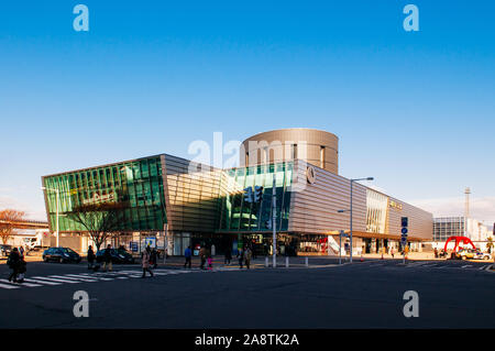 DEC 2, 2018 Hakodate, JAPAN - JR JR Hakodate Station building under bright sunlight in winter with tourists crossing road at junction. Stock Photo