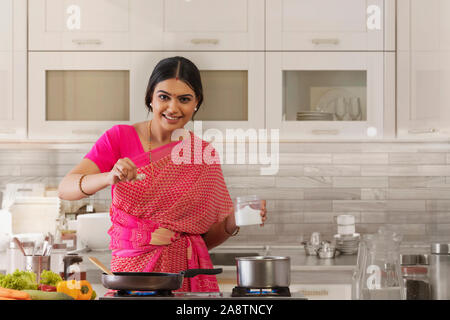 woman sprinkling salt in the dish Stock Photo
