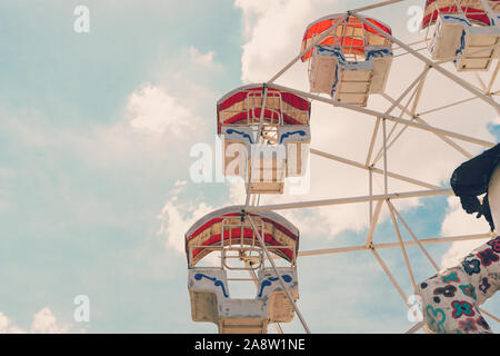 Ferris wheel on cloudy sky background with vintage toned. Stock Photo