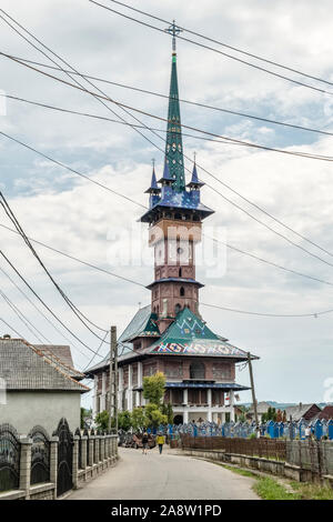 The brightly painted church at the famous Merry Cemetery in the village of Săpânța, Maramureş, northern Romania. Stock Photo