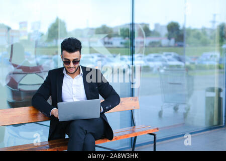 Cool guy arabic man uses laptop business center Stock Photo