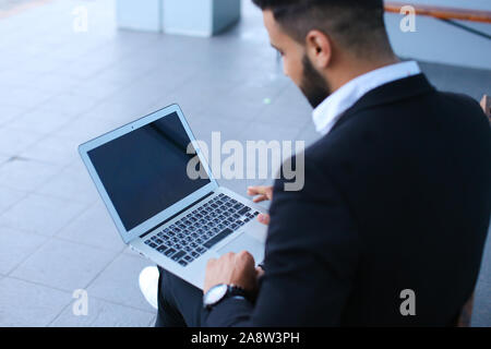 Cool guy arabic man uses laptop business center Stock Photo