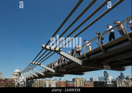 LONDON - MAY 25, 2012: Visitors line the Millennium Bridge, the first new bridge in the city since Tower Bridge in 1894. Stock Photo