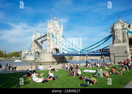 LONDON - OCTOBER 1, 2011: Sunbathers crowd the lawn at Potters Fields Park, one of the last remaining green open spaces on the Thames riverside. Stock Photo