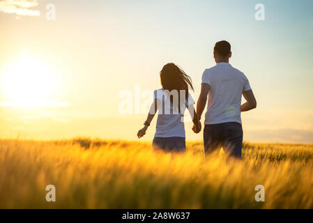 Love Couple running in  romantic summer field Stock Photo