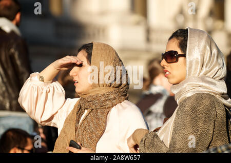 LONDON- OCTOBER 15, 2011: Young women wearing headscarves walk on a busy street in Central London. Stock Photo