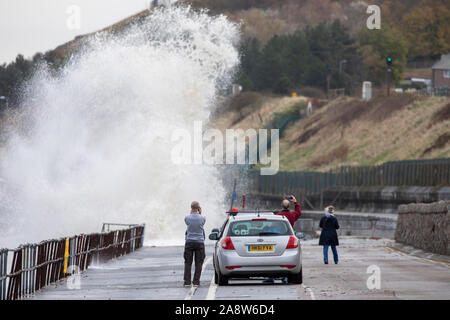 Colwyn Bay, North Wales, UK. 11th November 2019. UK Weather Wet and windy at for many today with dangerous conditions on coastal areas with high tides causing huge waves as seen at Colwyn Bay in North Wales as these wave watchers discovered Credit: DGDImages/Ģ����ý Live News Stock Photo