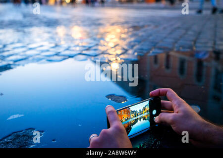 Man taking pictures of the cathedral of Saint Peter from the Vatican, reflected in the pond Stock Photo