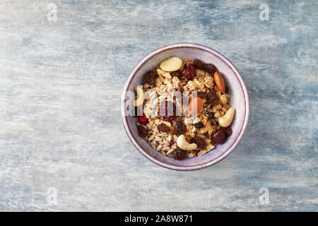 Bowl of granola with nuts and raisins. Concept for a tasty and healthy meal. Stock Photo