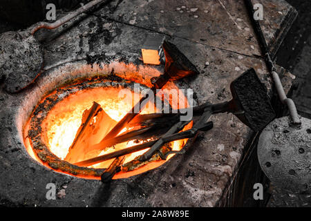 In a foundry workshop. Bronze metal bars are melted in a crucible Stock Photo