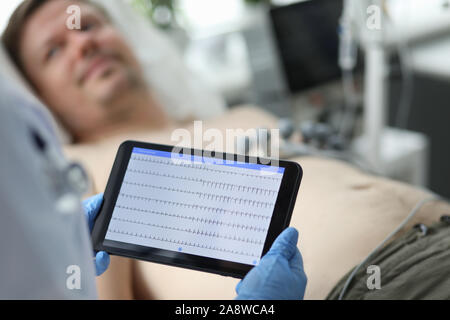 Female doctor hold in hand tablet pc with patient electrocardiogram Stock Photo