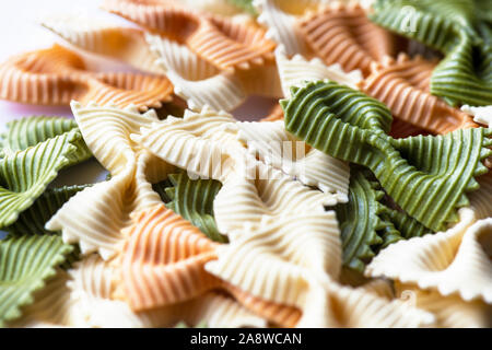 farfalle pasta tri-colored close up bow or ribbon selective focus background for copy space or text overlay Stock Photo