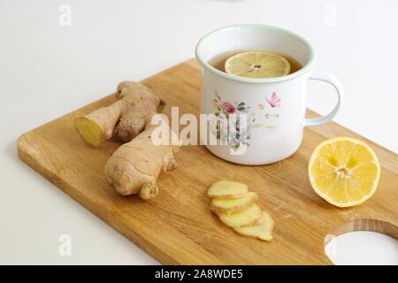 Closeup shot of ginger and ginger tea with lemon in the decorative container