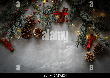 Christmas mood border with fir tree branches, cones and cinnamon sticks with red details and a copy space Stock Photo