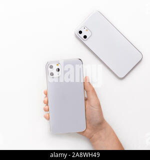 KHARKIV, UKRAINE - OCTOBER 18, 2019: Choose the best. Customer holding new IPhone 11 Pro in silver set with three camera lenses, isolated on white bac Stock Photo
