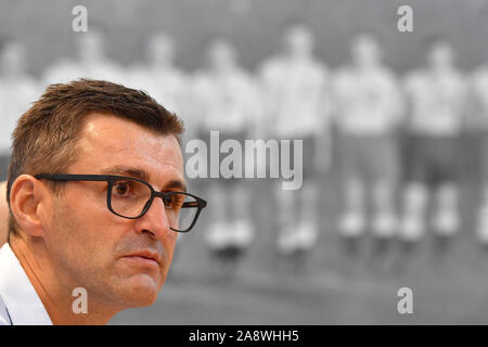 Munich, Germany. 11th Nov, 2019. Michael KOELLNER (coach 1860) in front of a historic black and white photo of a Sechzger crew. Single picture, single cut motif, portrait, portrait, portrait. Official presentation Michael KOELLNER as new coach at TSV Munich 1860, | usage worldwide Credit: dpa/Alamy Live News Stock Photo