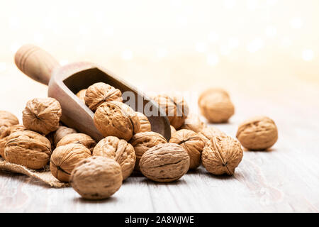 bunch of walnuts with wooden scoop on table Stock Photo