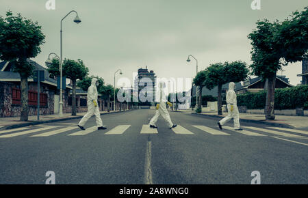 People with bacteriological protection suits in a crosswalk Stock Photo