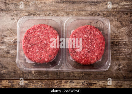 burger meat packaged in plastic on wooden table. Top view Stock Photo