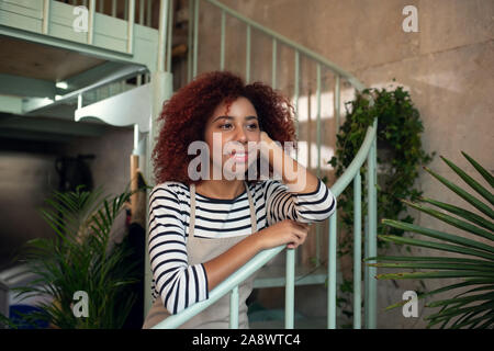 Curly young woman feeling excited before starting work Stock Photo