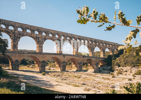 Pont du Gard Bridge on the Gardon River near Avignon - view of the bridge through tree branches in early autumn Stock Photo