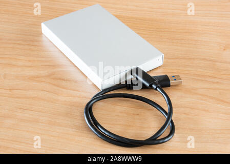 An external hard drive to connect to a laptop computer for data transfer or data backup. Stock Photo