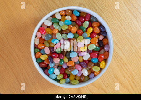 An assortment of brightly coloured jelly beans in a white bowl - sweets or candy Stock Photo