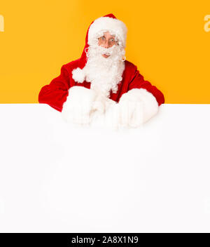 Santa Claus with big blank banner on orange background Stock Photo