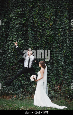 fun and crazy brides. happy gorgeous bride and stylish groom jumping