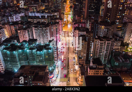 Car, taxi, and bus traffic on road intersection at night in Hong Kong downtown district, drone aerial top view. Street commuter Asia city life concept Stock Photo