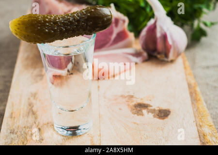 A shot of vodka and a pickled cucumber on a glass is a snack in Ukrainian Stock Photo