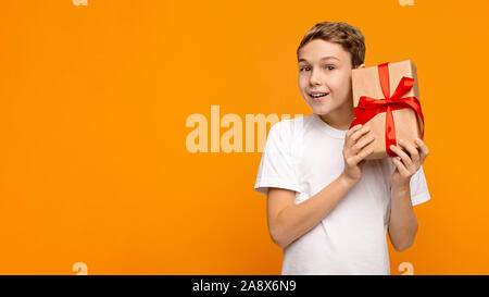 Curious boy shaking present box, trying to guess what inside Stock Photo