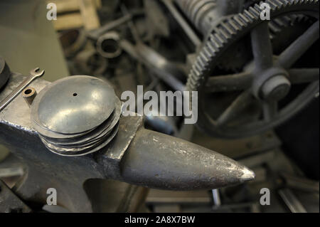 Anvil and machine cogwheels, detail of smithy Stock Photo