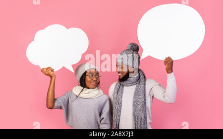 Young black winter couple holding communication bubbles at studio Stock Photo