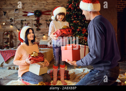 Content parents with girl exchanging with presents Stock Photo