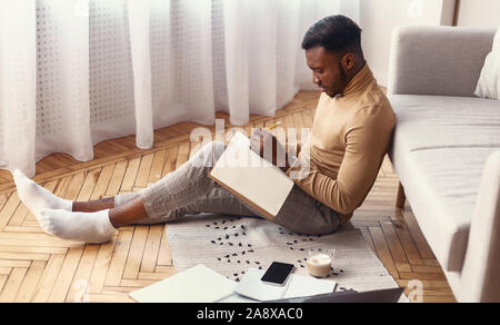 Young Man Taking Notes Studying Sitting On Floor At Home Stock Photo