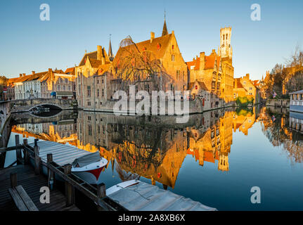 Early morning photograph of a canal in Bruges, with view of the Church of Our Lady Stock Photo