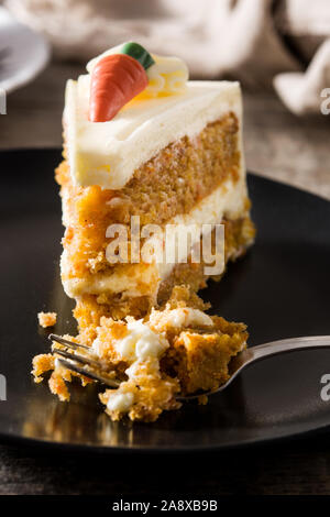 Sweet carrot cake slice on a plate on wooden table Stock Photo