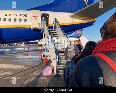 London, England - november 9th, 2019: queue of people waiting to get on a Ryanair aircraft at stansted airport in a cold sunny day