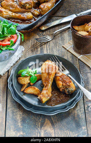 Chicken drumsticks in ginger beer sauce with potato wedges and salad - high angle view Stock Photo