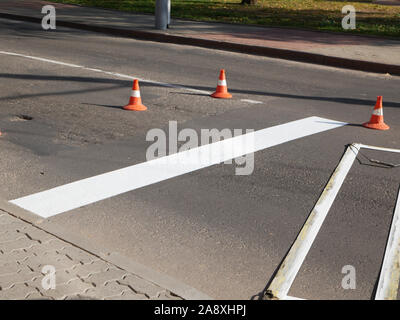 Road marking. Drawing a road marking. spraying in road construction. Worker draws a white line on the surface of the street. Stock Photo