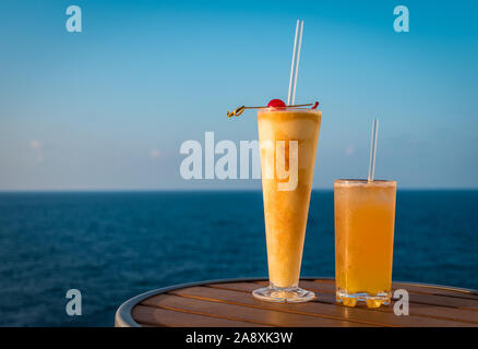 Delicious holiday cocktail drinks on a table of a cruise ship. Sea background. Stock Photo