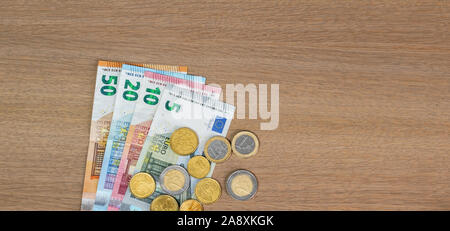 Euro currency banknotes and coins on wooden background. Stock Photo
