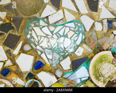 Background from multi-colored tiles on the wall. Pattern of broken tiles. pieces of tile on the wall. Stock Photo